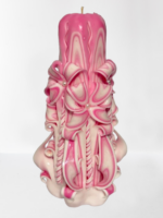 Geschnitzte rosa Kerze mit symbolischen Motiven eines Engels und eines Kreuzes, die Liebe und Schutz repräsentieren.